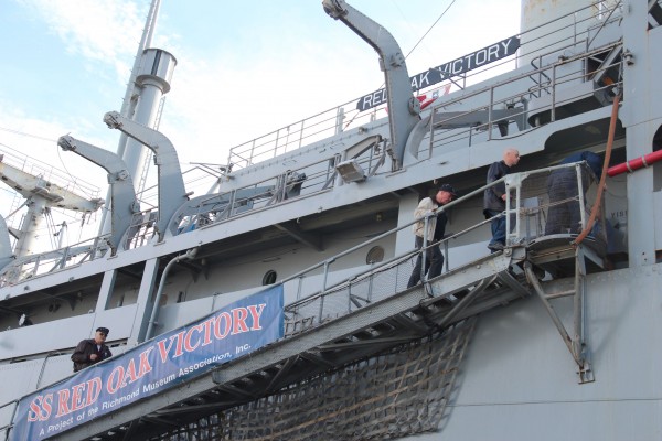 Veteran’s Day attendees file onboard the SS Red Oak Victory at the Port of Richmond for a memorial wreath toss. (Photo by: Kevin N. Hume)
